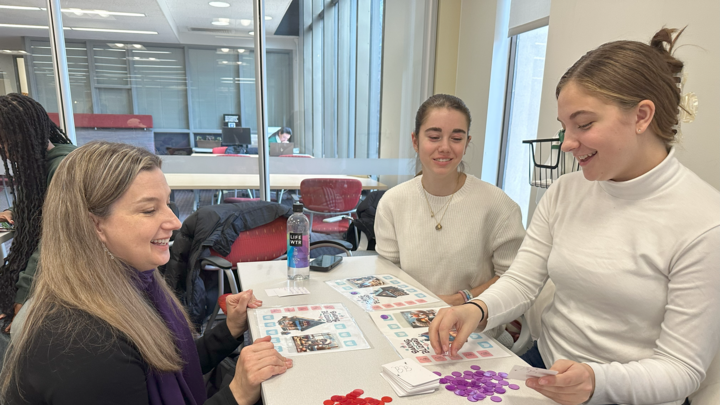 Students showcasing their boardgame with their professor