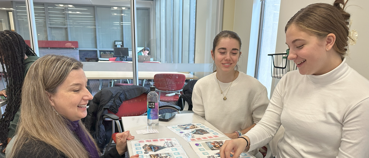 Students showcasing their boardgame with their professor